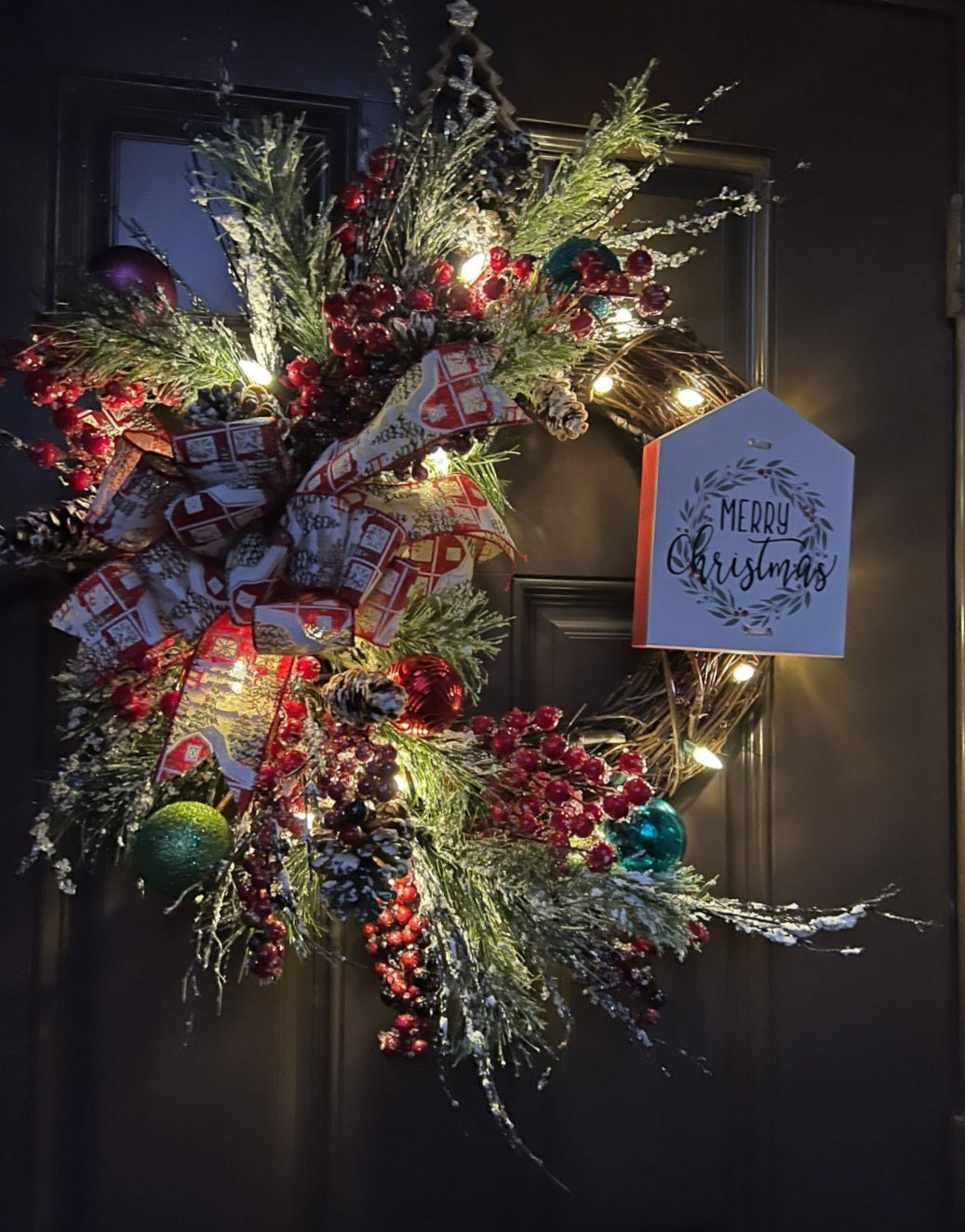 Christmas wreath with a message in a wood sign