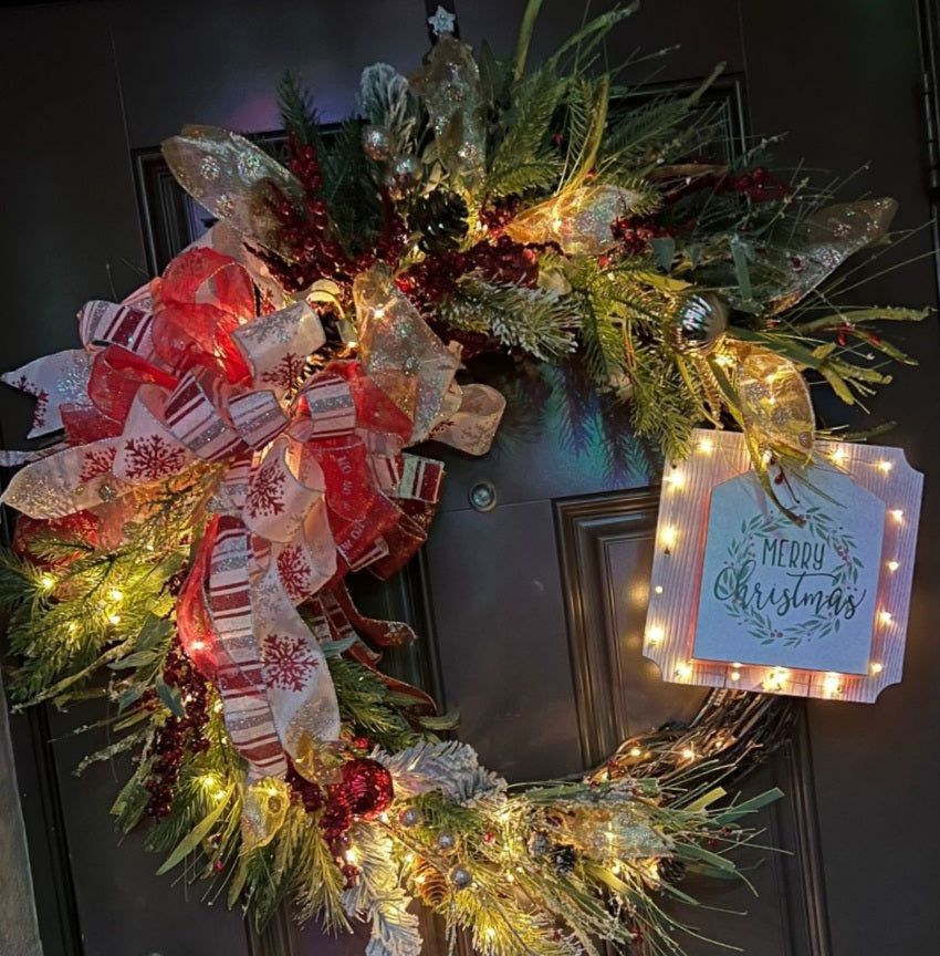 Christmas wreath with a message in a wood sign